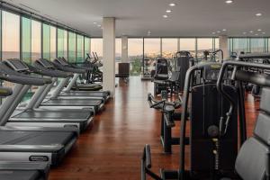 un gimnasio con filas de cintas de correr y máquinas de ejercicio en Grand Hotel River Park, a Luxury Collection Hotel, Bratislava en Bratislava