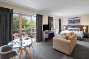 um quarto de hotel com uma cama, uma mesa e cadeiras em Kimberley Gardens Hotel, Serviced Apartments and Serviced Villas em Melbourne