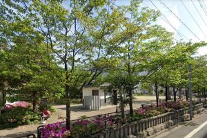 a park with flowers and trees and a fence at KOTORI HOUSE in Kyoto
