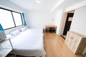 een kleine kamer met een bed en een tafel bij SUA HOTEL Nishikasai in Tokyo