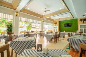 un restaurant avec des tables et des chaises bleues et blanches dans l'établissement La Vintage Resort, à Patong Beach