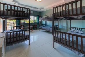 a room with three bunk beds and a table at HOUSE OF HAPPINESS in Thongsala