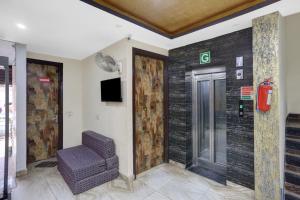 eine Lobby mit einem Stuhl und einem Aufzug in der Unterkunft OYO Flagship Hotel Blue Orchid in Neu-Delhi