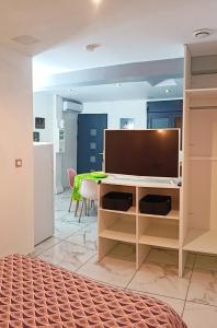 a living room with a tv on a desk at Studio mitoyen avec piscine partagée - Résidence Plaiz'Anse in Petite Île
