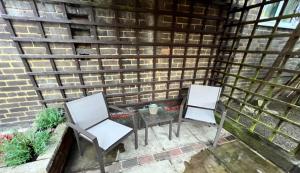 twee stoelen en een tafel op een patio bij Comfy Room for ONE person - Netflix, Amazon Prime & Disney Plus in Bromley