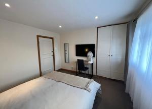 a bedroom with a bed and a desk and a television at Comfy Room for ONE person - Netflix, Amazon Prime & Disney Plus in Bromley