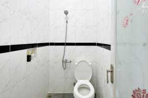 a bathroom with a toilet in a shower stall at Adipura Guesthouse Syariah Mitra RedDoorz near Terminal Nganjuk in Nganjuk