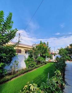 um quintal com relva verde e uma casa em Bora's Homestay em Haldwani