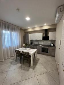 a kitchen with a white table and chairs in it at B&B Lamezia Central Airport in SantʼEufemia Lamezia