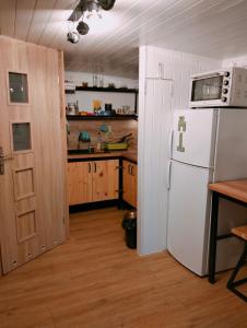 a kitchen with a white refrigerator and a microwave at Domek letniskowy przy Orliku Cisna działka in Cisna