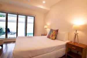 a bedroom with a bed and a large window at Beachfront on Mission - Absolute Beachfront in Mission Beach +33 photos