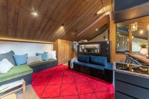 - un salon avec un canapé et un tapis rouge dans l'établissement La Grange aux Hirondelles - Saint-Malo - St Servan, à Saint-Malo