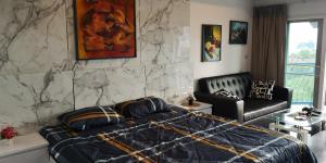 ein Schlafzimmer mit einem Bett und einem Sofa in der Unterkunft Villa Germania in Jomtien Beach