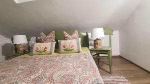 a bedroom with a bed with pillows and a green chair at Dridif 135 in Dridif