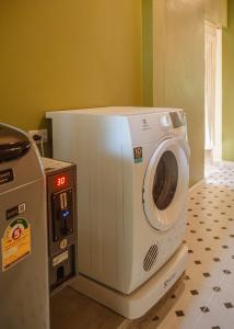 a white microwave sitting on top of a refrigerator at Society House Luxury Hostel in Pai