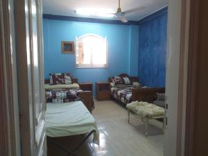 Mourad House في أسوان: غرفة معيشة مع جدران زرقاء وأريكة