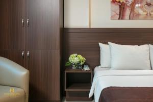 ein Hotelzimmer mit einem Bett und einem Tisch mit Blumen in der Unterkunft Quang Chung Hotel Le Van Thiem in Hanoi