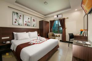 ein Hotelzimmer mit einem Bett und einem Schreibtisch in der Unterkunft Quang Chung Hotel Le Van Thiem in Hanoi
