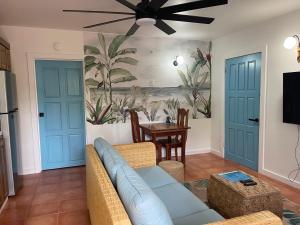 a living room with a couch and a ceiling fan at Alux House in Placencia Village
