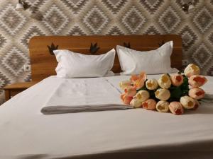 a bed with two flowers on top of it at Dridif 135 in Dridif
