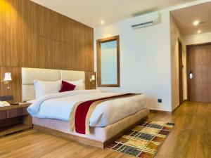 a bedroom with a large bed and a mirror at Asian Buddha Hotel in Bhairāhawā