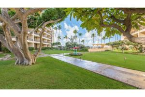 a park with a building and trees and grass at SUGAR BEACH RESORT, #326 condo in Kihei