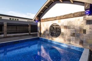 a swimming pool with a tile wall and an archway at Fugaku Gunjo in Izu