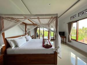a bedroom with a bed with a canopy at Bhakti Ubud Villa in Ubud