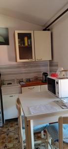 cocina con mesa blanca y microondas en Affitta stanza da Paola INTRA Lago, en Intra