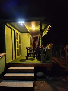 a porch with a table and chairs at night at Chalet in Petreto-Bicchisano