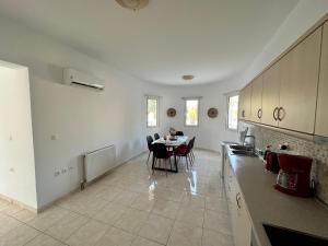 a kitchen and dining room with a table and chairs at Treditto House - Ground Floor residence C1 in Koskinou +13 photos
