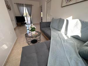 a living room with a couch and a table at Treditto House - Ground Floor residence C1 in Koskinou