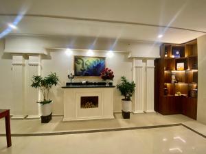 a living room with a fireplace and a painting at Le Centre Pleiku Hotel in Pleiku