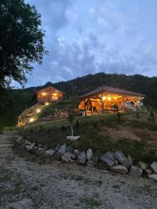 a log cabin with lights on a hill at night at Chalets du BF in Sighişoara