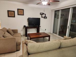 a living room with two couches and a television at Departamento de lujo. Seguridad 24. Playa a pasos. in Acapulco