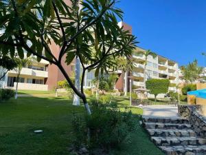 a palm tree in a park next to a building at Departamento de lujo. Seguridad 24. Playa a pasos. in Acapulco