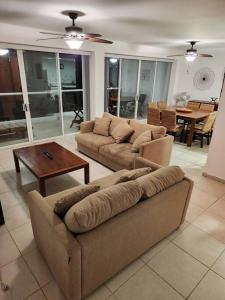 a living room with two couches and a table at Departamento de lujo. Seguridad 24. Playa a pasos. in Acapulco