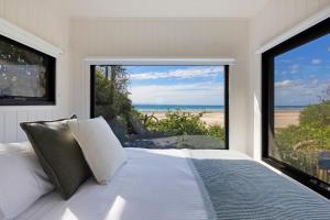 a bedroom with a bed with a view of the beach at Reflections Byron Bay - Holiday Park in Byron Bay