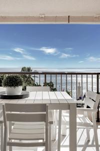 a white table and chairs on a balcony with the ocean at Aquarius Luxury Apartment in Cairns