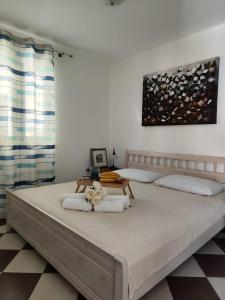 um quarto com uma cama grande e toalhas em Apartmani Roko em Okrug Donji