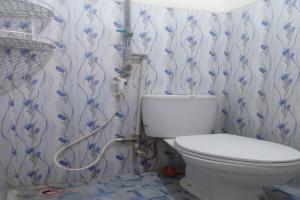 a bathroom with a toilet and a hose at OYO 92816 Ana Homestay in Banyuwangi