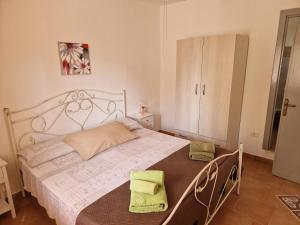 una camera da letto con un grande letto bianco con due sedie di Appartamenti Turistici Aprile Anna Laura a Borgagne