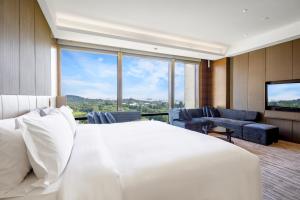 a bedroom with a white bed and a large window at InterContinental Nantong, an IHG Hotel-Best view of yangtze in Nantong