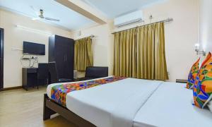 een hotelkamer met een groot bed en een bureau bij Dover Inn By BookMeriHotel in Calcutta