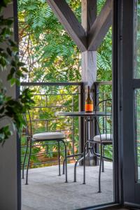 een tafel en stoelen op een balkon met een fles wijn bij Rustic Central Studios by LH in Boedapest
