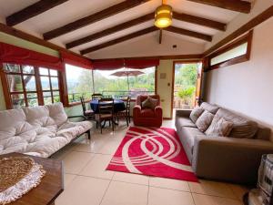 a living room with couches and a dining room at Cabañas Vistas al Río Villarrica in Villarrica