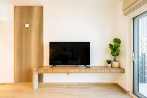 a living room with a flat screen tv on a wall at 1br Apartment In Waters Edge Hosted By Voyage in Abu Dhabi