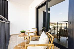 a balcony with chairs and a table on a balcony at 1br Apartment In Waters Edge Hosted By Voyage in Abu Dhabi