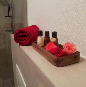 - une étagère dans la salle de bains avec 3 bouteilles de savon et de roses dans l'établissement Dreilärchenhaus, à Brixen im Thale