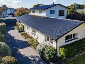 eine Luftansicht eines Hauses mit Metalldach in der Unterkunft The Airport Homestay House in Christchurch
